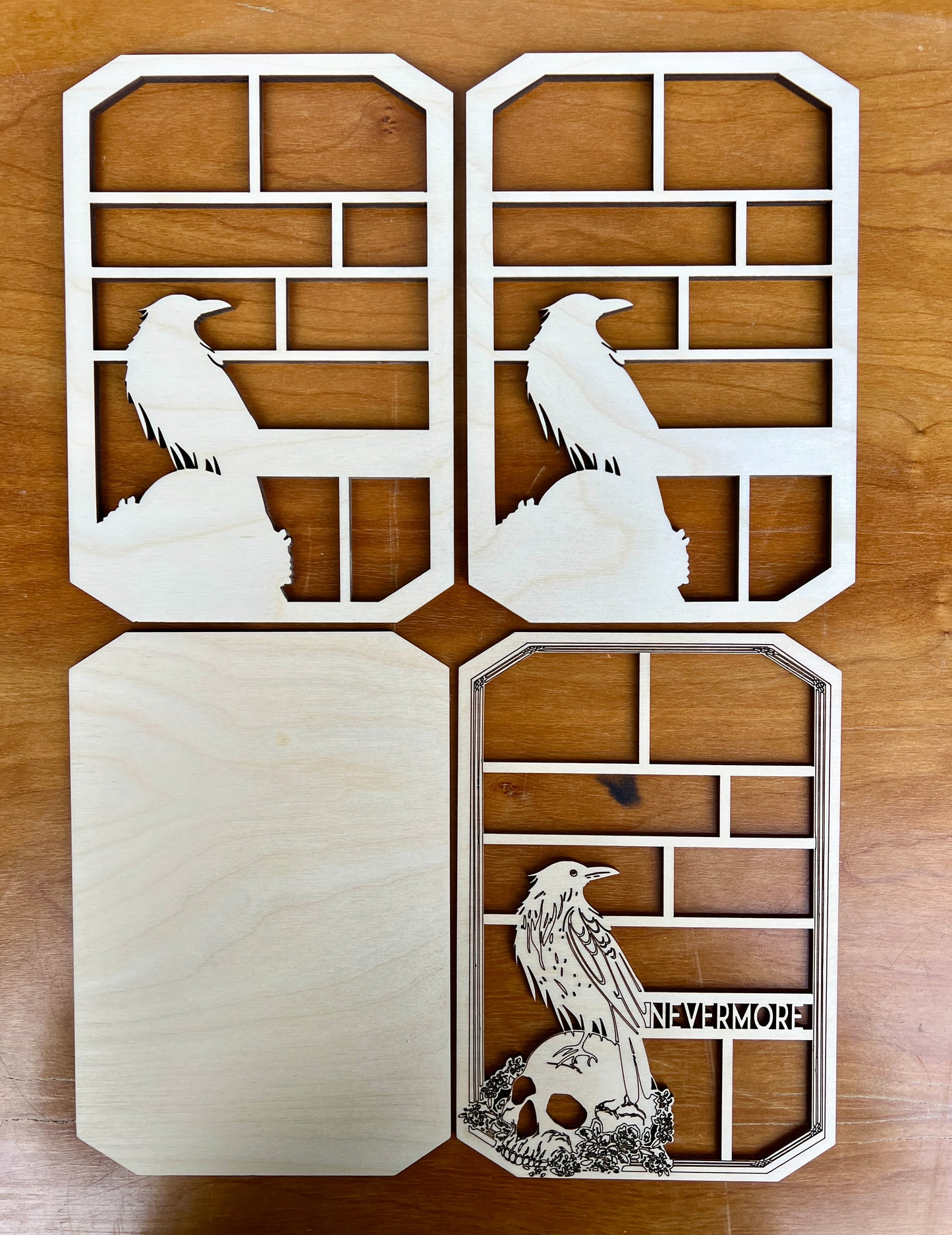Decorative wall art with cut-out designs of ravens and 'Nevermore' text on a wooden surface.