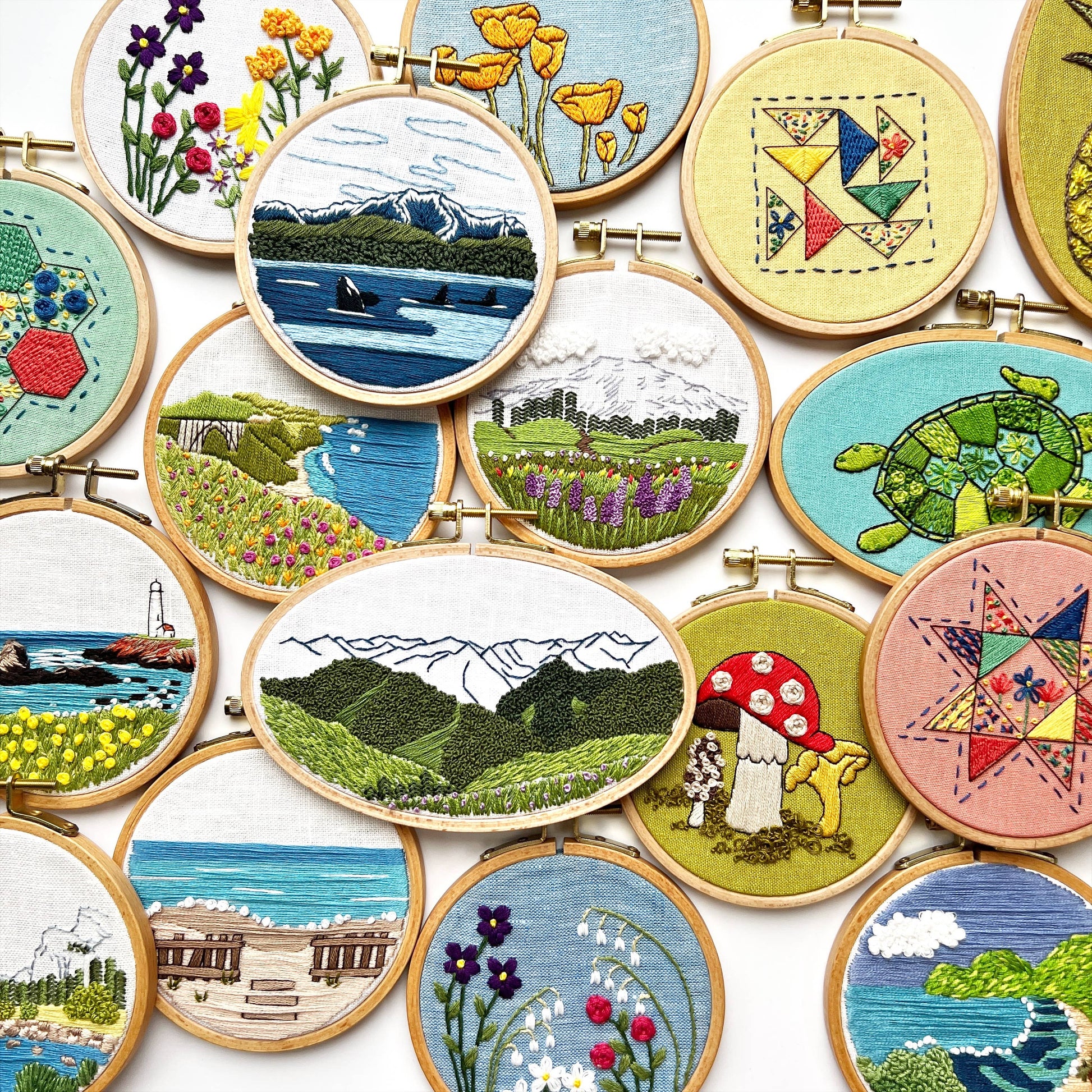 Collection of embroidered scenes in various hoops on a white background