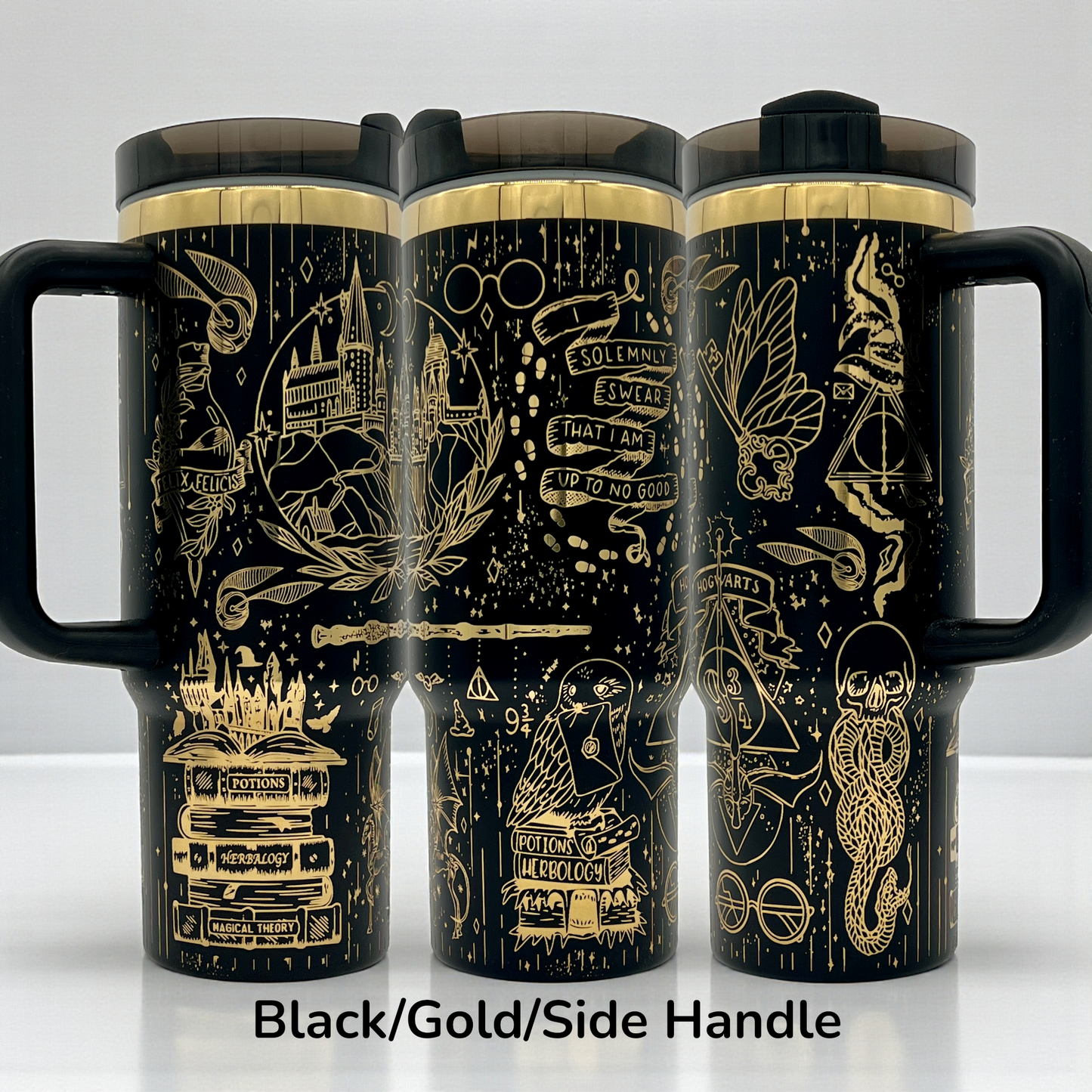 Black travel mugs with gold magical symbols and text, featuring side handles.