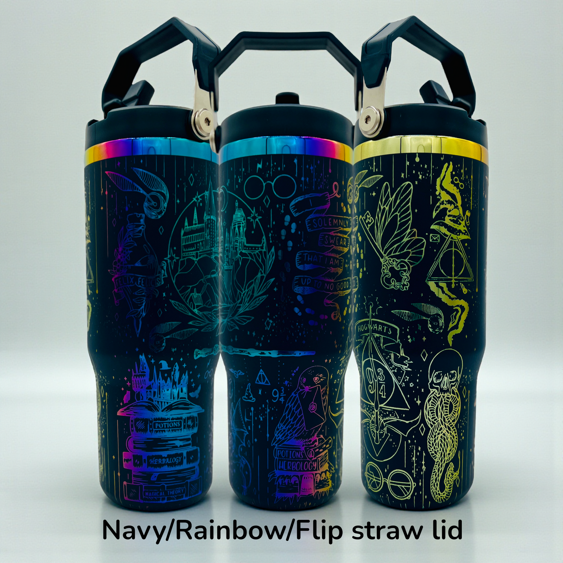Three navy tumblers with rainbow lids, featuring magical-themed line art and flip straw lids.