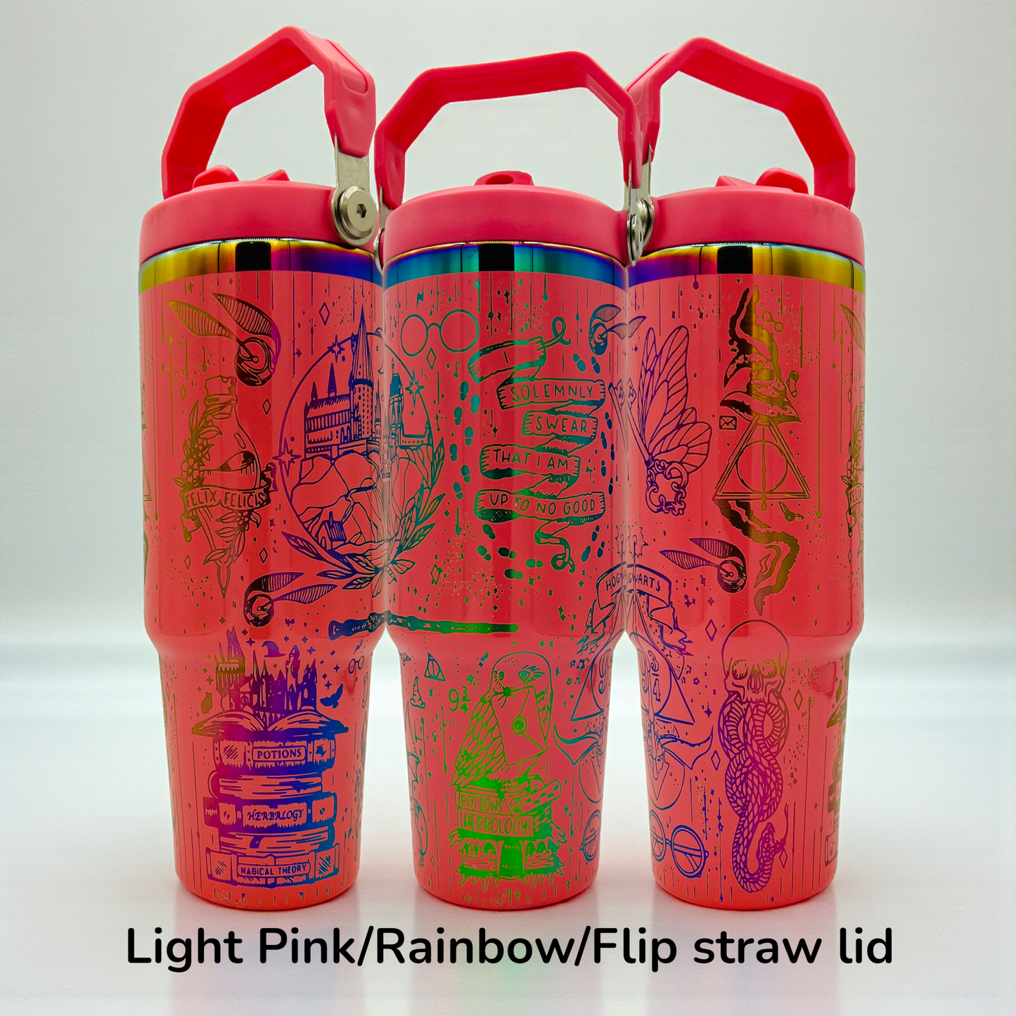 Three pink cups with rainbow lids, decorated with intricate line art and magical symbols.