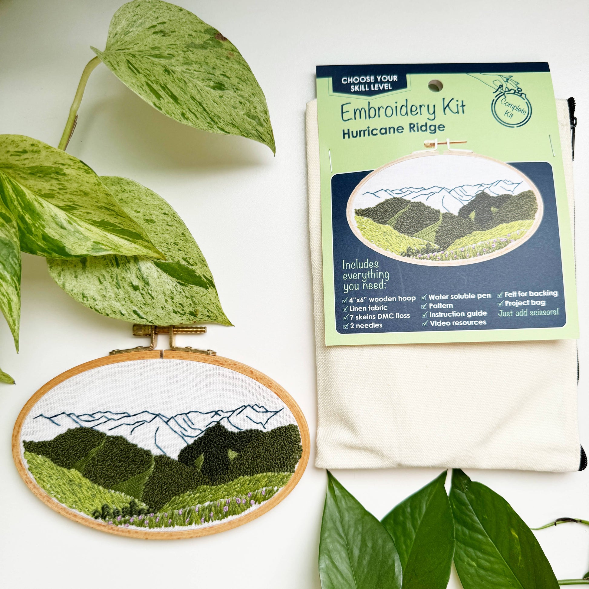 Embroidery kit with mountain design and leaves on a white background