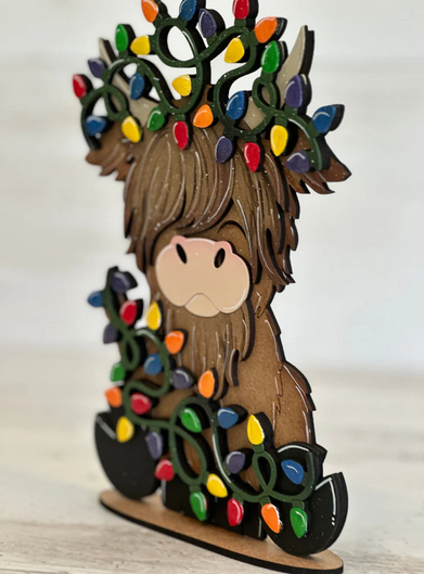 Cartoon brown animal with colorful lights on its head and body, standing on a wooden base.