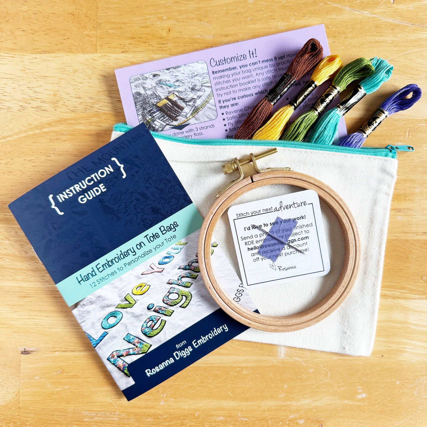 Embroidery kit with hoop, threads, and instruction guide on a wooden surface