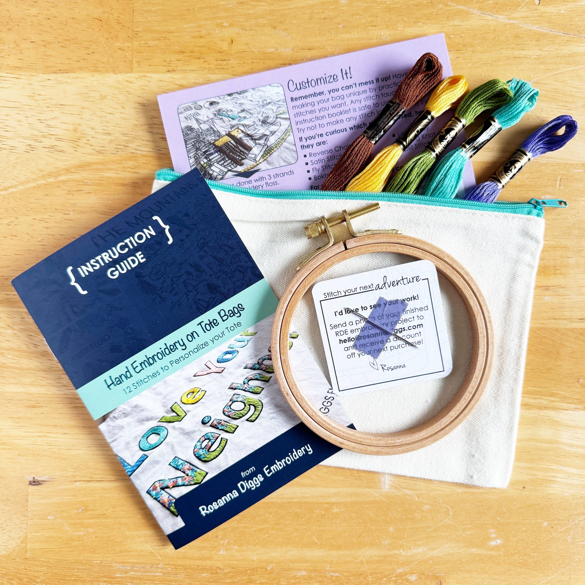 Embroidery kit with hoop, threads, and instruction guide on a wooden surface