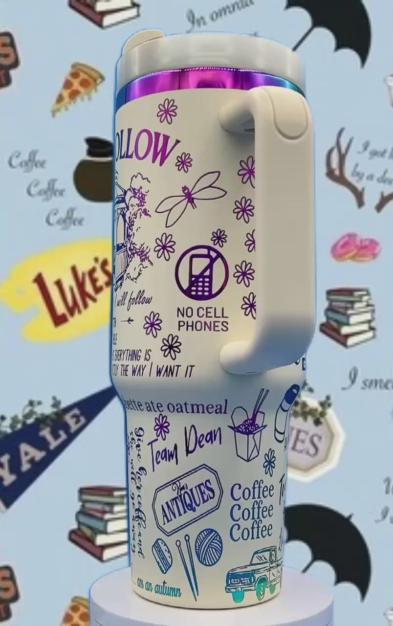 White travel mug with purple and blue graphics, featuring flowers, text, and various symbols.