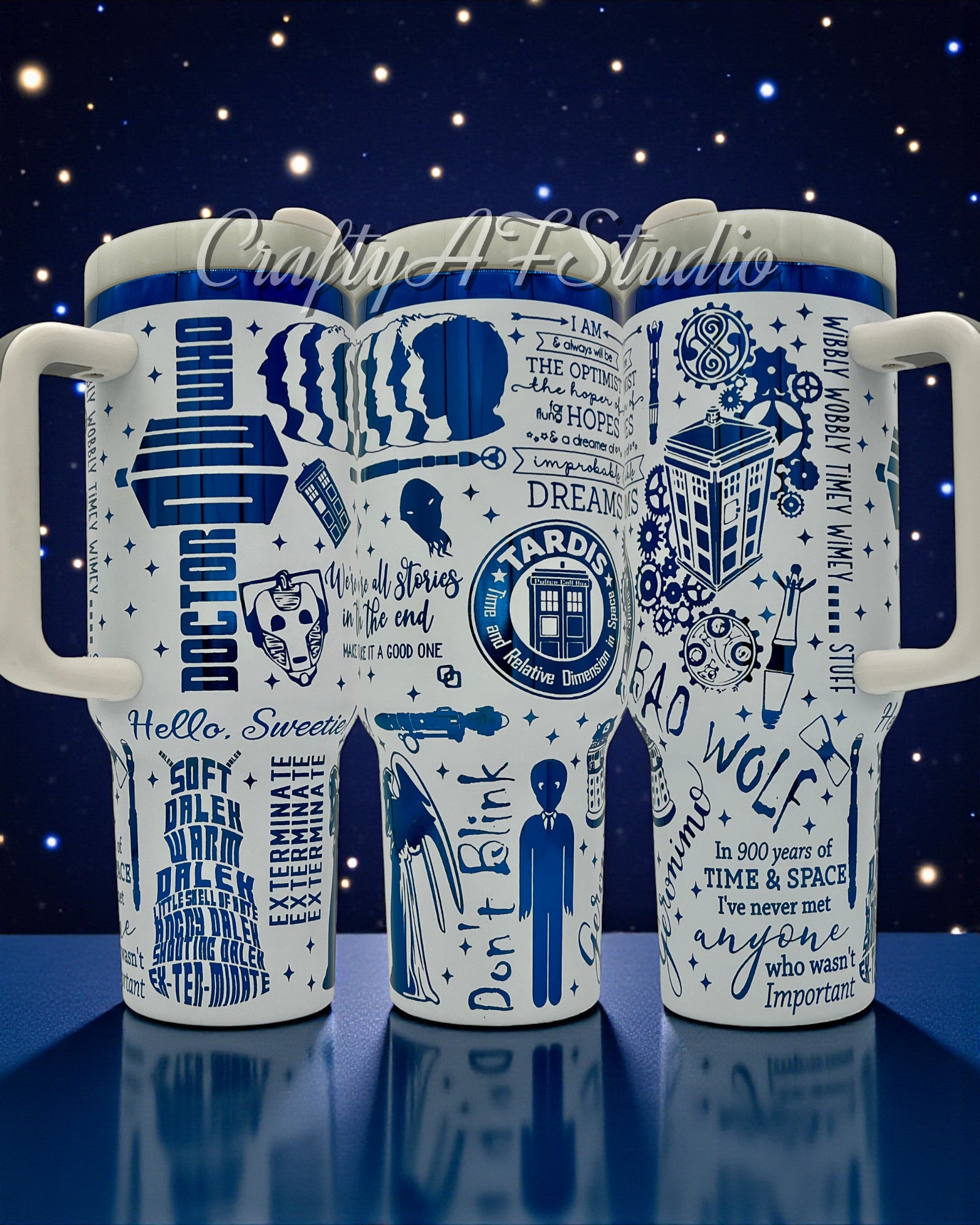 White mugs with blue Doctor Who designs and quotes, against a starry night backdrop.