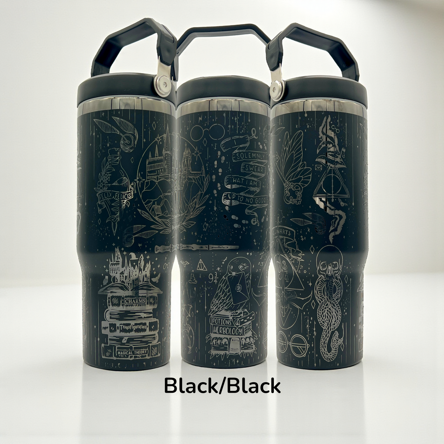 Three black tumblers with white intricate magical-themed doodles and black handles.