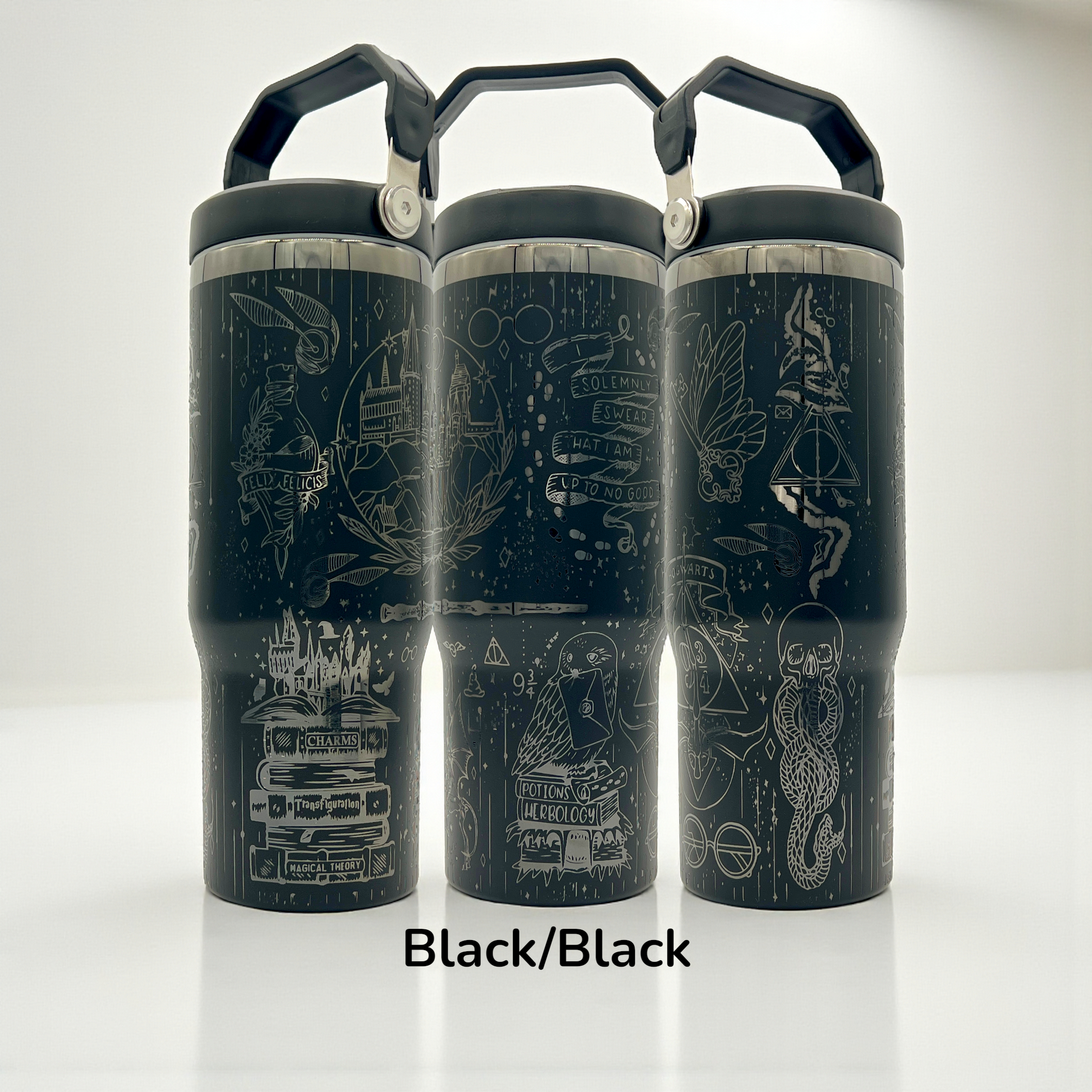 Three black tumblers with white intricate magical-themed doodles and black handles.